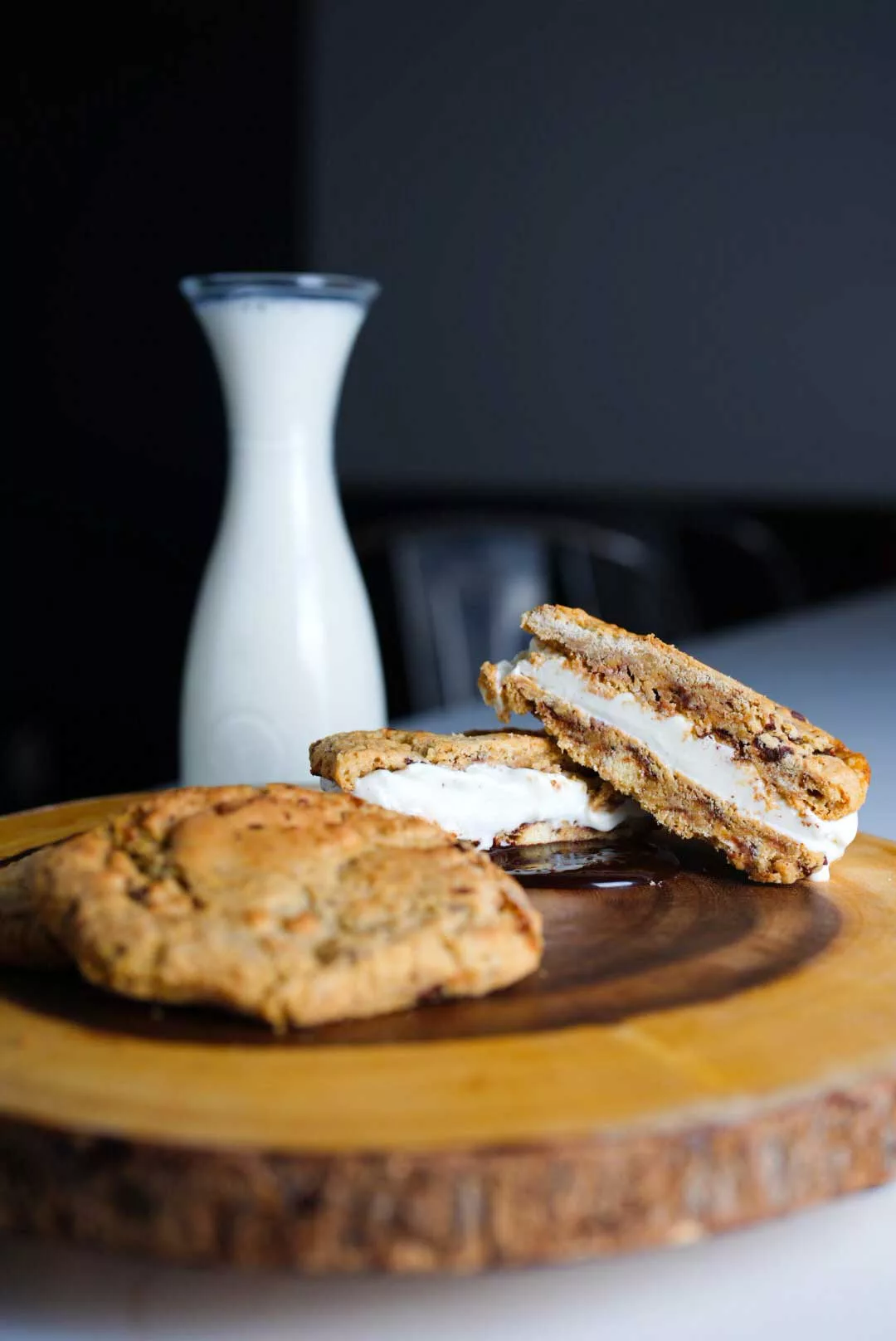 Cookie sandwiches with a pitcher of milk in the background